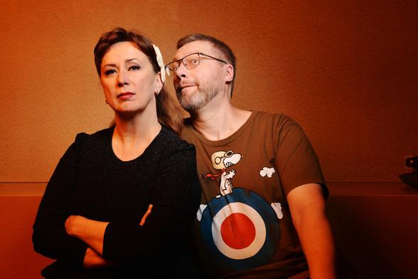 Martina und Martin sitzen nebeneinander. Sie versucht, cool und lässig zu gucken und Martin zieht heimlich eine Grimasse